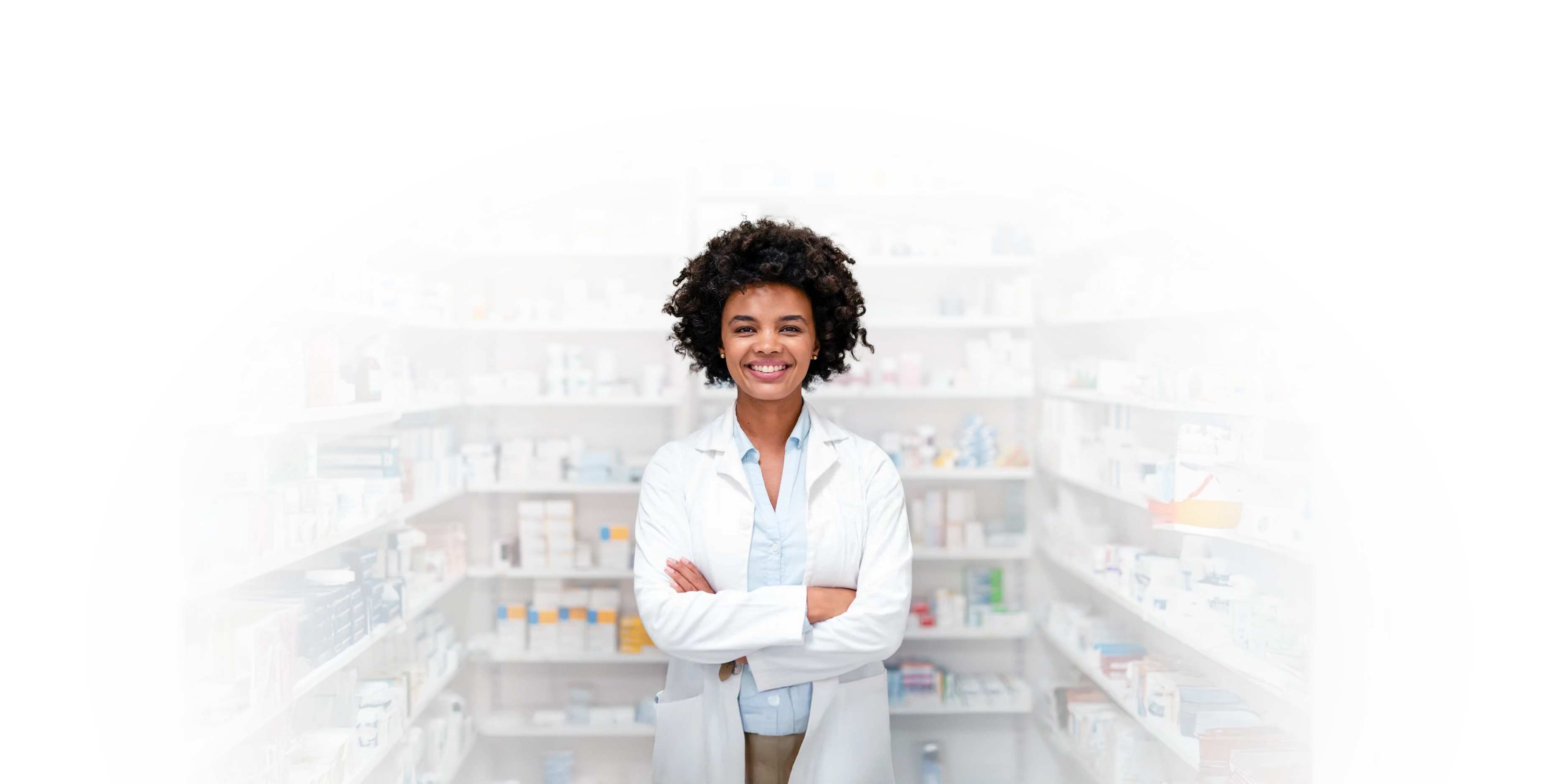 A smiling pharmacist with her arms crossed in her pharmacy